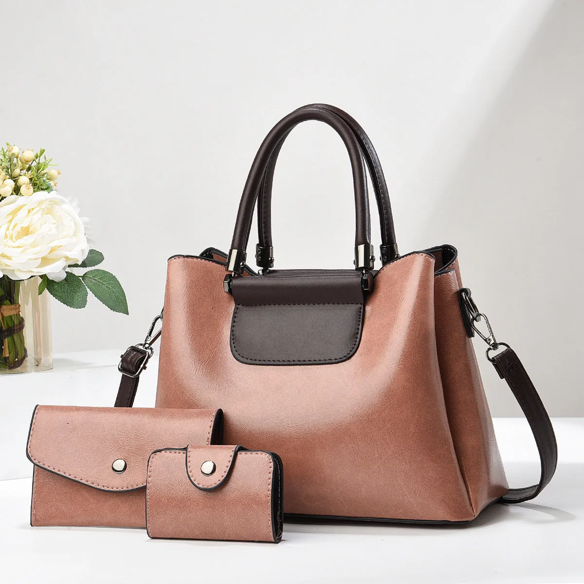 Large PU leather handbag set in horizontal square shape with matching medium and small pouches on white background