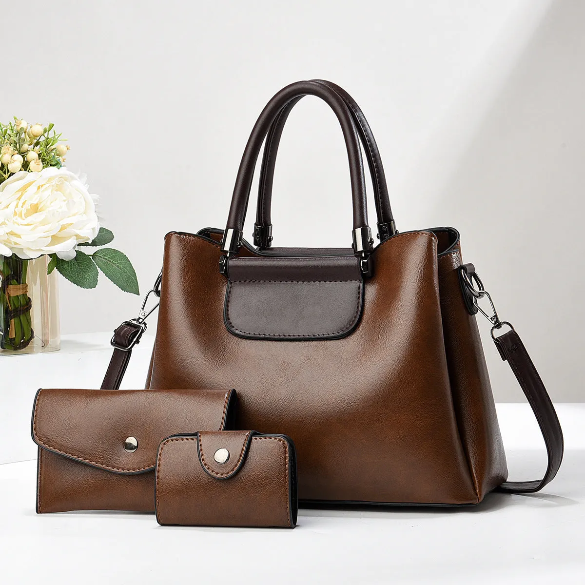 Large PU leather handbag set in horizontal square shape with matching medium and small pouches on white background