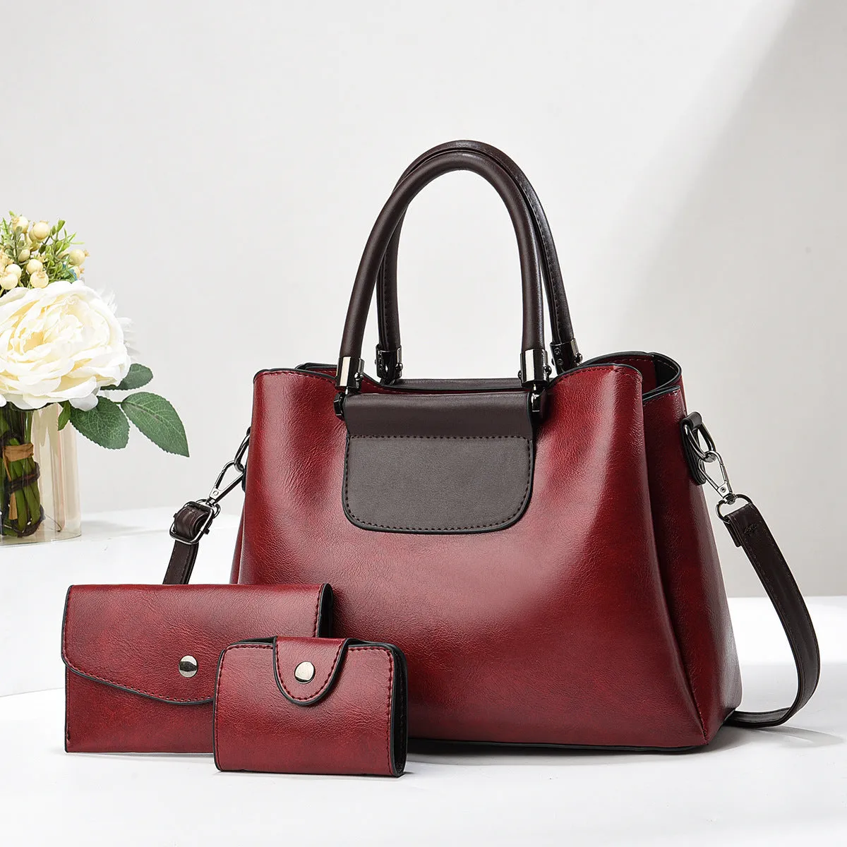 Large PU leather handbag set in horizontal square shape with matching medium and small pouches on white background