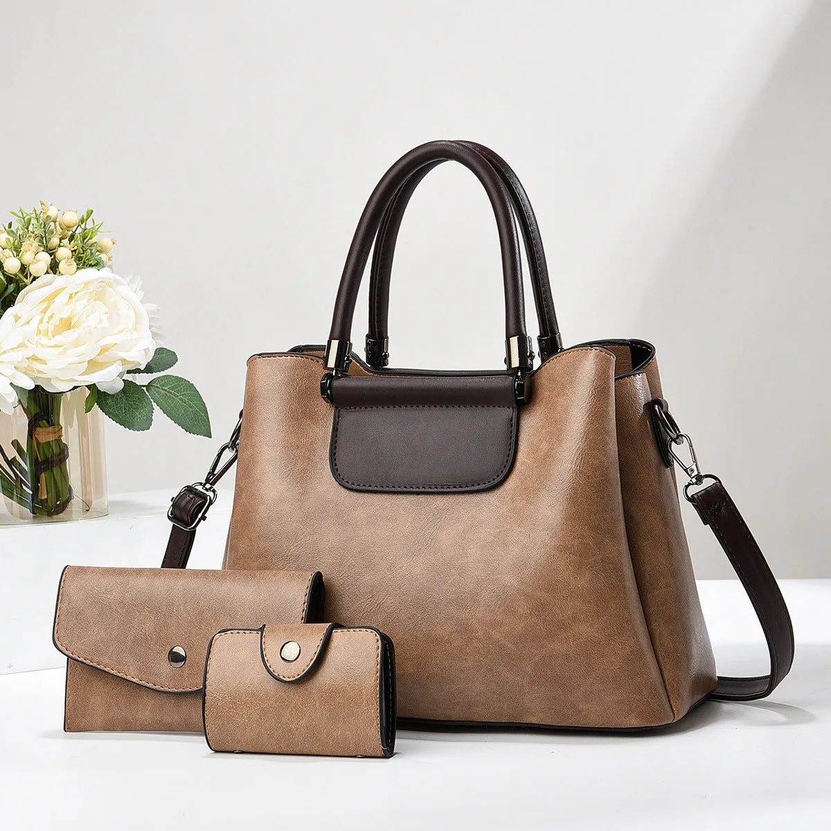 Large PU leather handbag set in horizontal square shape with matching medium and small pouches on white background