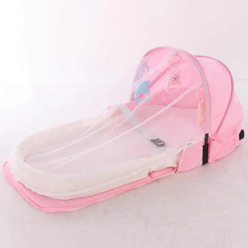 Portable foldable baby anti-mosquito isolation bed with grey cotton linen fabric, open on a grassy area