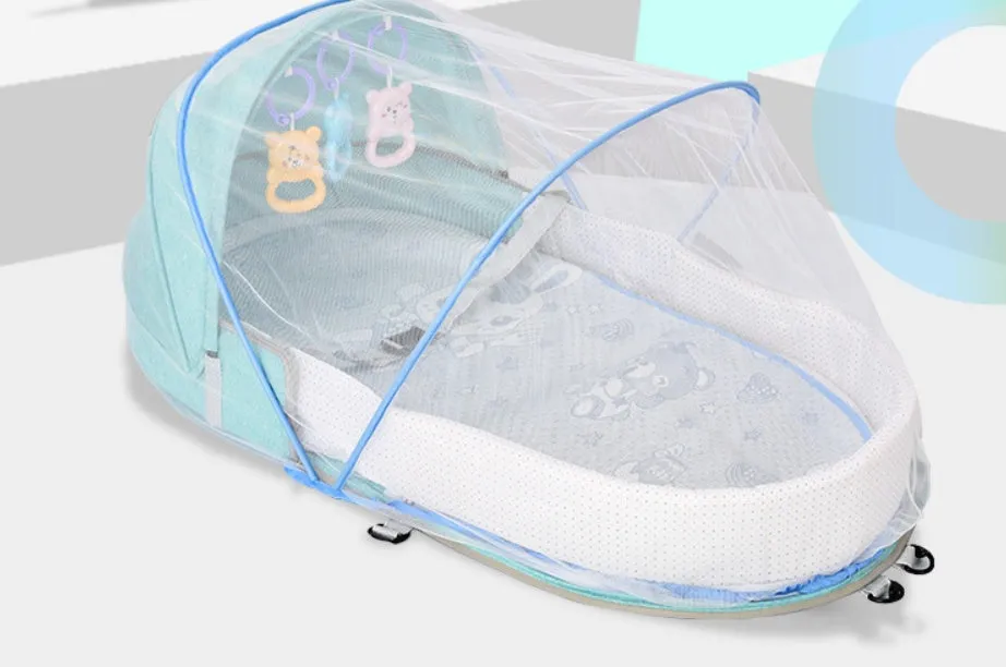 Portable foldable baby anti-mosquito isolation bed with grey cotton linen fabric, open on a grassy area