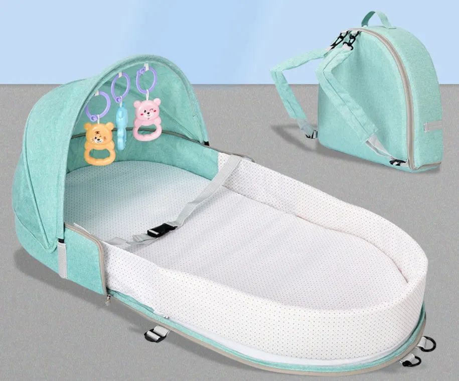 Portable foldable baby anti-mosquito isolation bed with grey cotton linen fabric, open on a grassy area