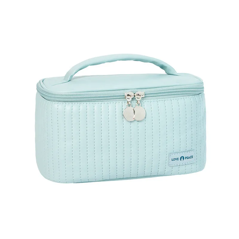 Open-top PU leather makeup bag in a solid colour, showing cosmetics and brushes inside.