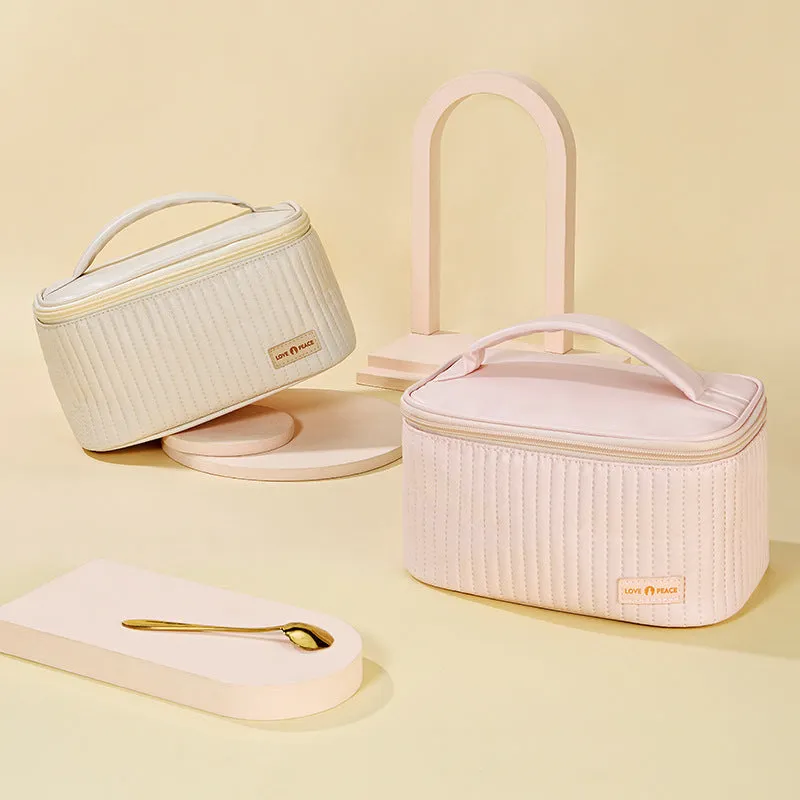 Open-top PU leather makeup bag in a solid colour, showing cosmetics and brushes inside.