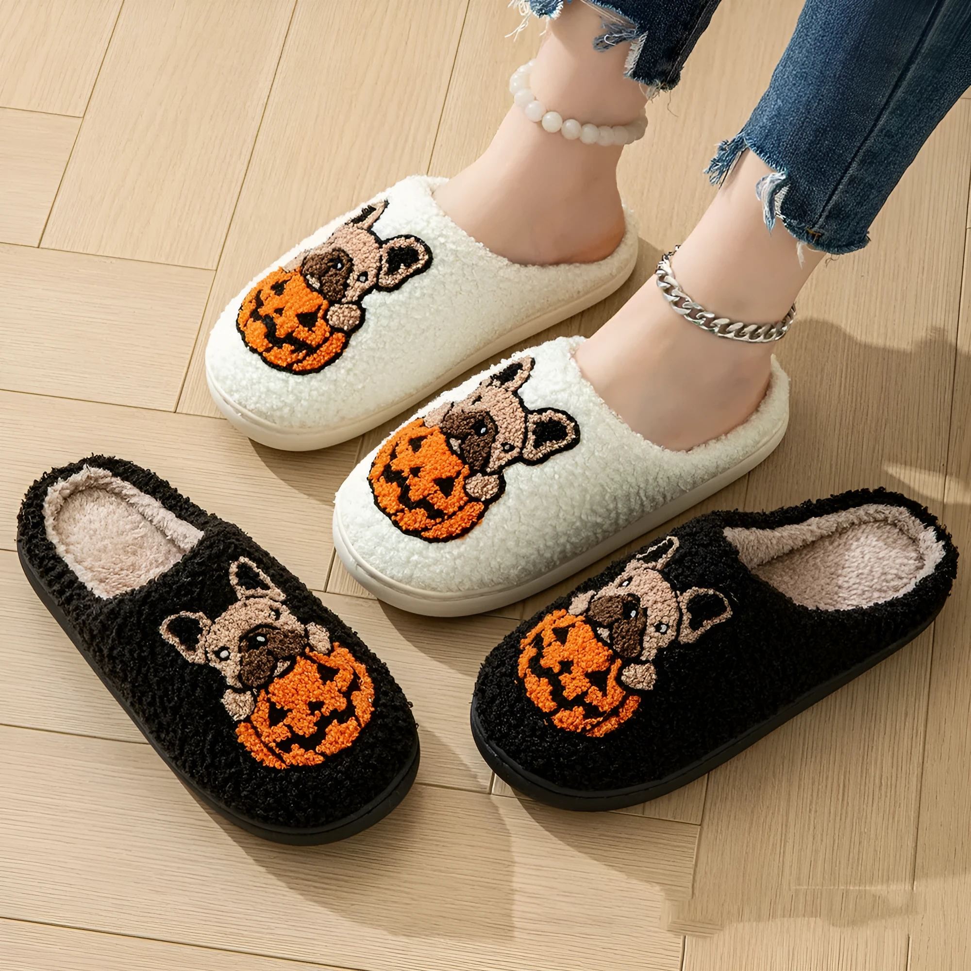 Black and white Halloween slippers with pumpkin pattern, plush upper, and textured rubber sole.