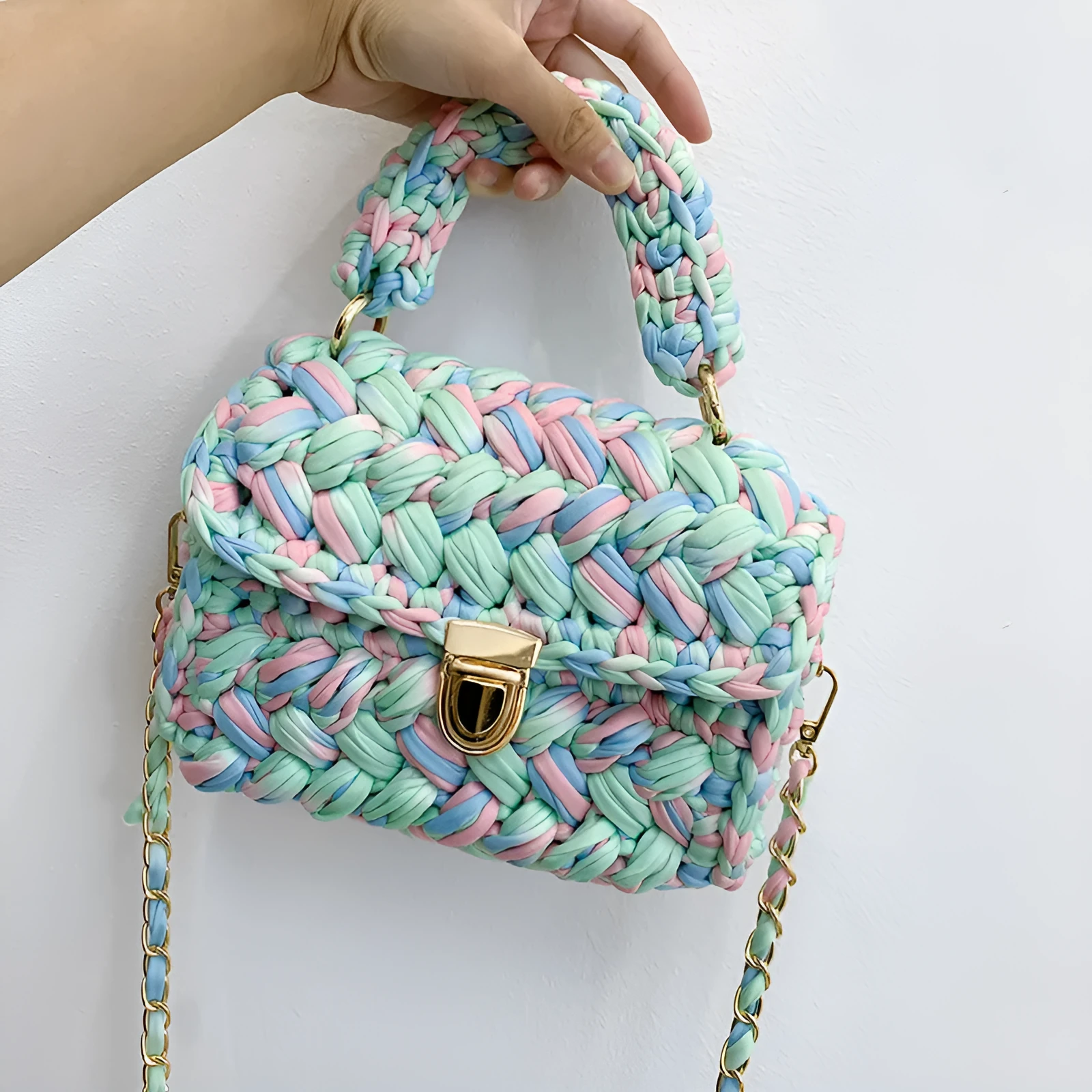 Hand knitted crochet tote crossbody bag in cotton with lock closure, yellow colour, on a plain background