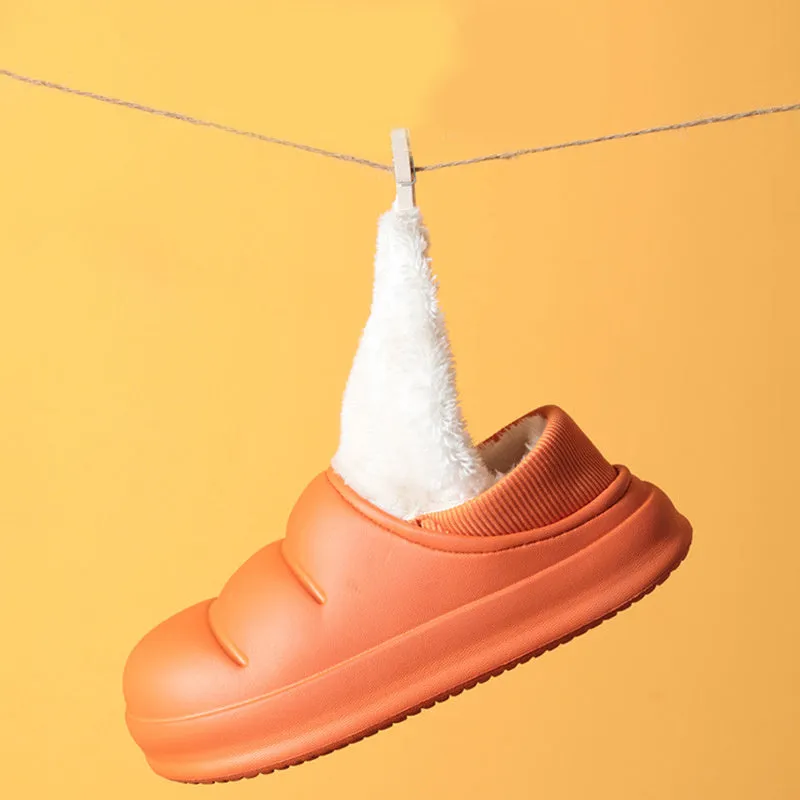 Yellow women's EVA overshoe slippers with plush lining and a textured non-slip sole on a wooden deck.