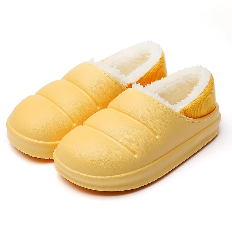 Yellow women's EVA overshoe slippers with plush lining and a textured non-slip sole on a wooden deck.