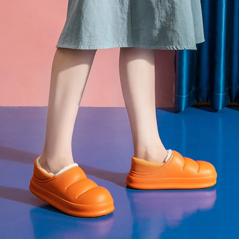 Yellow women's EVA overshoe slippers with plush lining and a textured non-slip sole on a wooden deck.