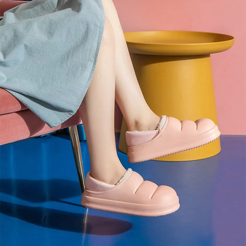 Yellow women's EVA overshoe slippers with plush lining and a textured non-slip sole on a wooden deck.