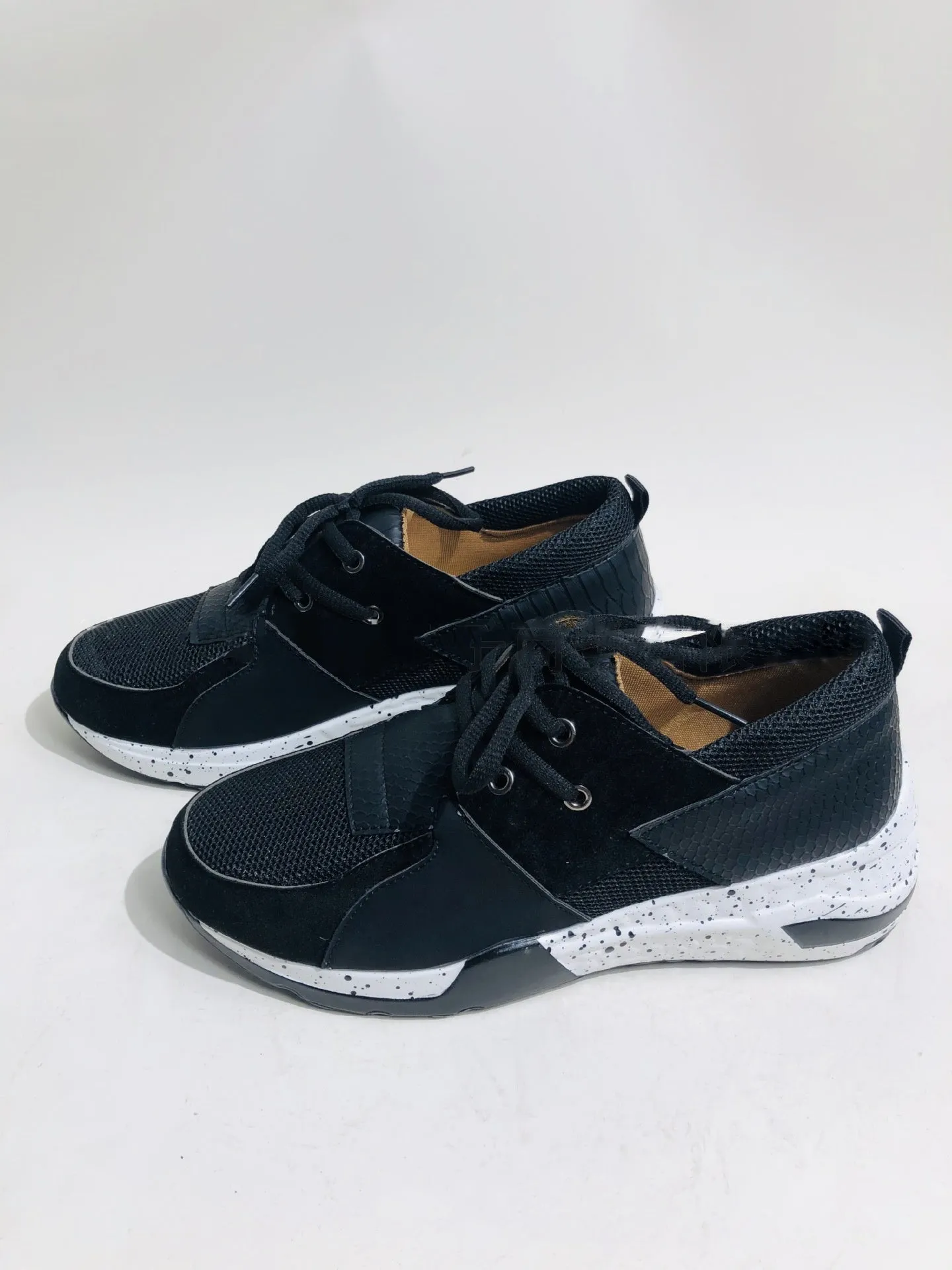 Women's casual wedge heel sneakers in suede, showing round toe and low-cut profile on a wooden floor.