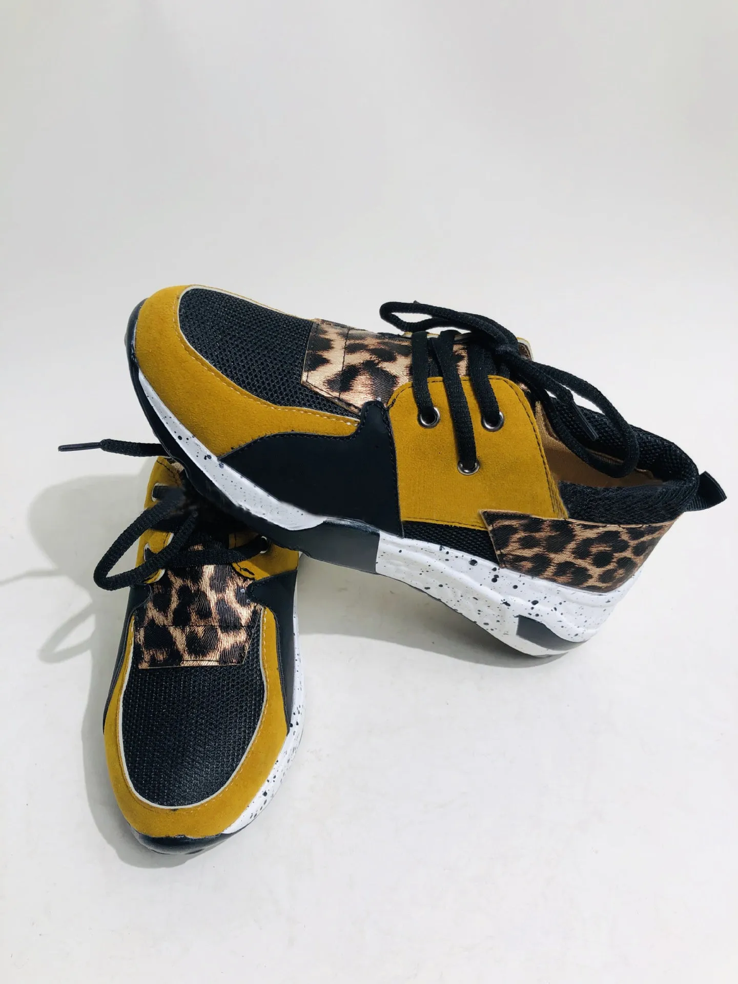 Women's casual wedge heel sneakers in suede, showing round toe and low-cut profile on a wooden floor.