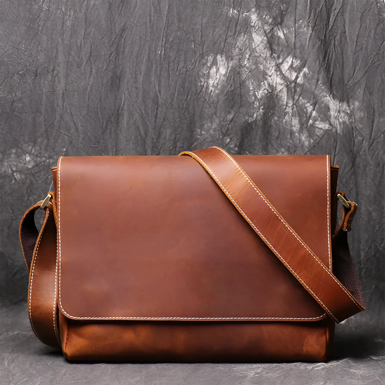 Vintage brown cowhide men's messenger bag showing front flap and adjustable shoulder strap