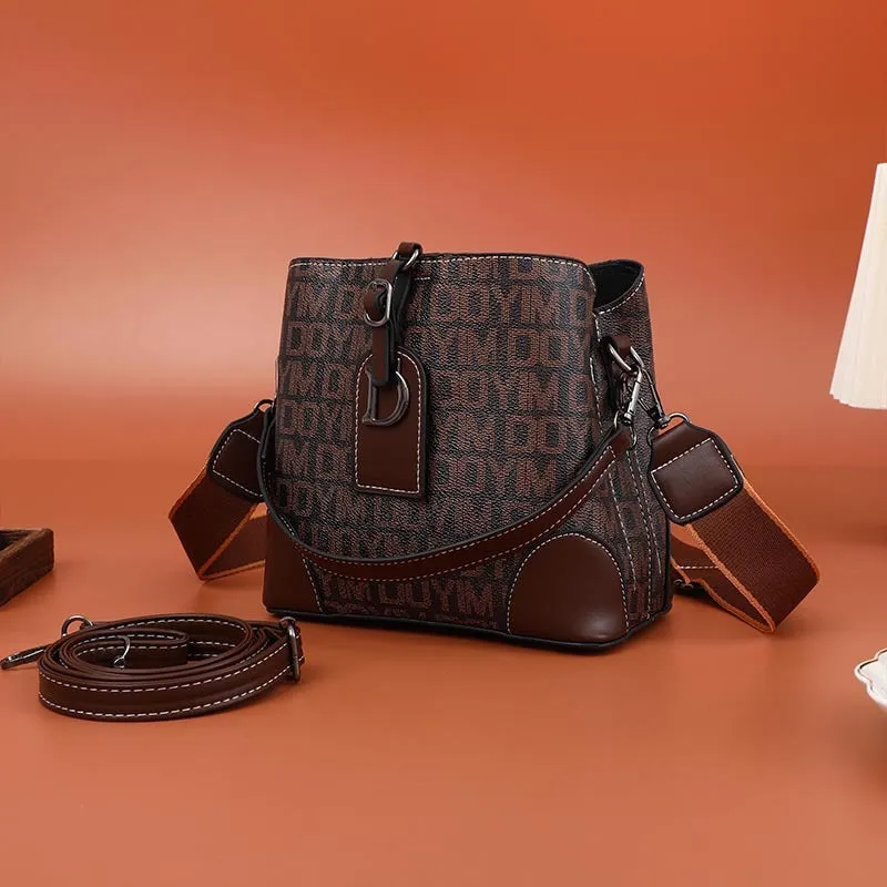 Women's soft PU bucket bag with tassel and contrast colour stitching on a plain background