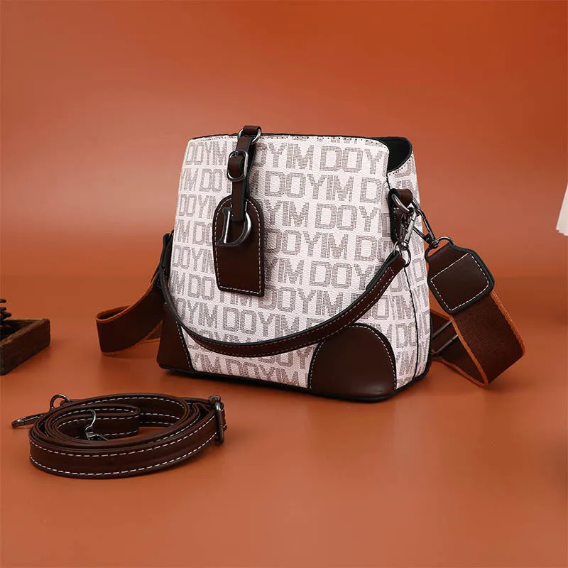 Women's soft PU bucket bag with tassel and contrast colour stitching on a plain background