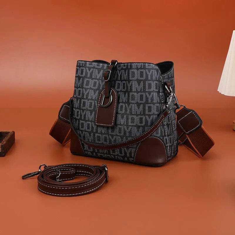 Women's soft PU bucket bag with tassel and contrast colour stitching on a plain background