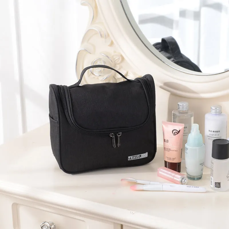Cube-shaped cationic toiletry bag in black, folded open to show interior storage space