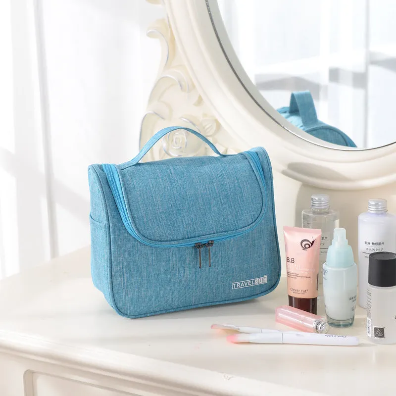 Cube-shaped cationic toiletry bag in black, folded open to show interior storage space