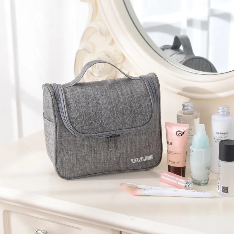 Cube-shaped cationic toiletry bag in black, folded open to show interior storage space