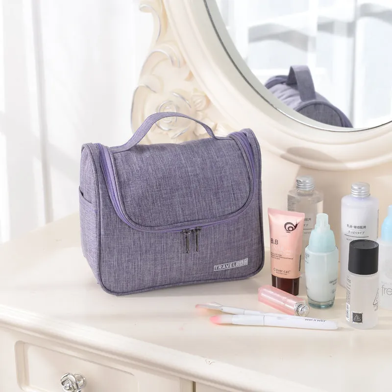 Cube-shaped cationic toiletry bag in black, folded open to show interior storage space