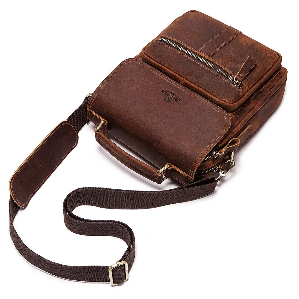Men's brown leather shoulder bag with zipper buckle closure on soft surface