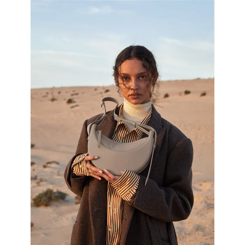 Women's crescent shoulder bag with litchi pattern texture, available in camel, black, chalk white, and elephant gray