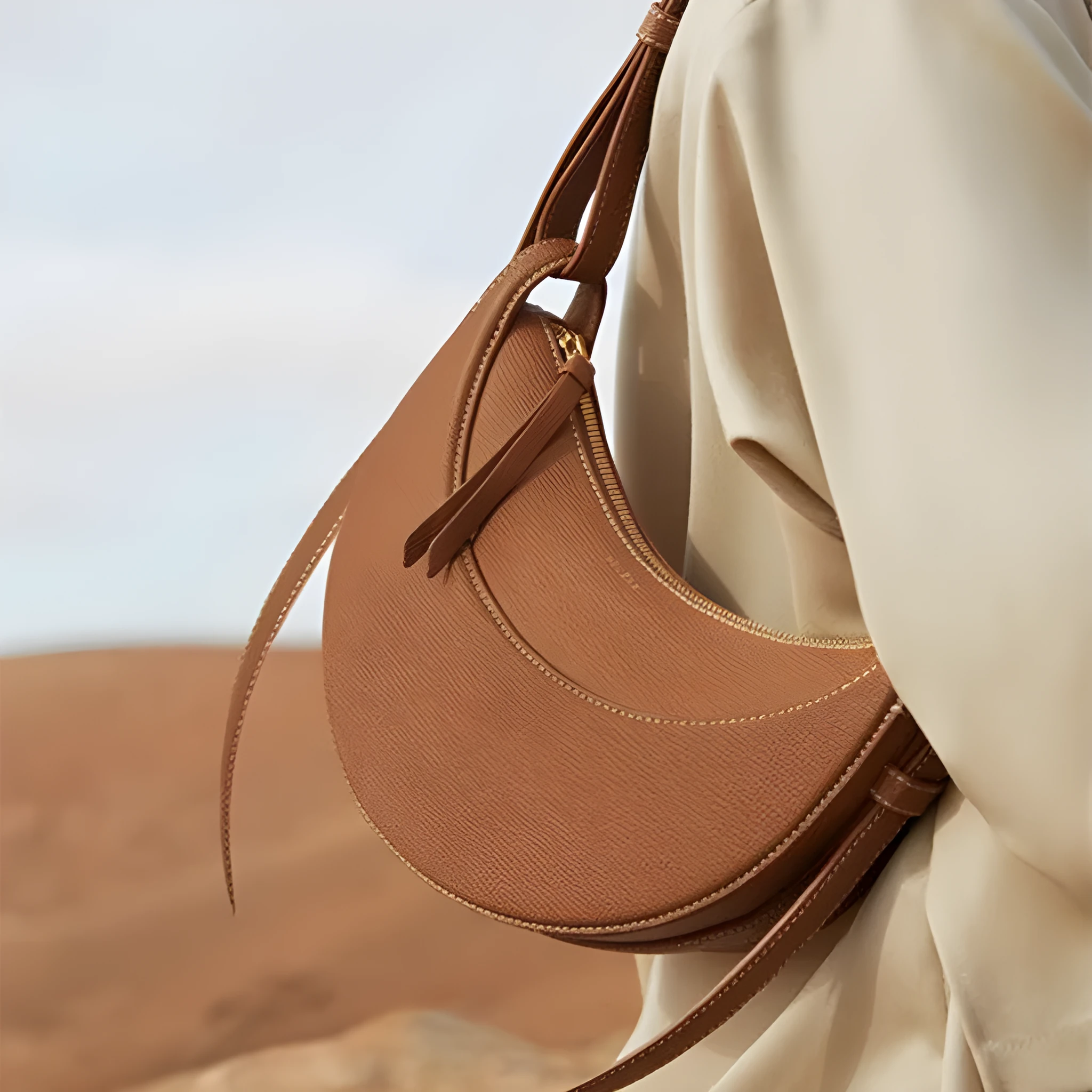 Women's crescent shoulder bag with litchi pattern texture, available in camel, black, chalk white, and elephant gray