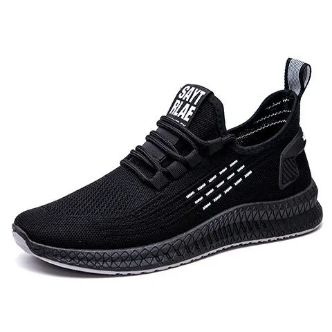 Men's low-top black casual trainers with cross-strap detail and flying weave upper, shown on a white background.