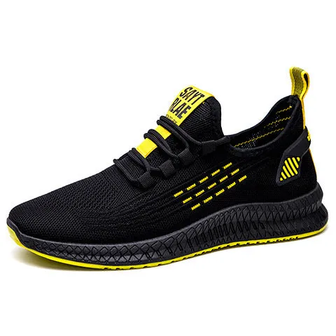 Men's low-top black casual trainers with cross-strap detail and flying weave upper, shown on a white background.