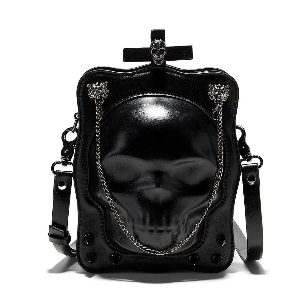 Black mini square crossbody bag with embossed skull design, metal chain strap, and zip opening.