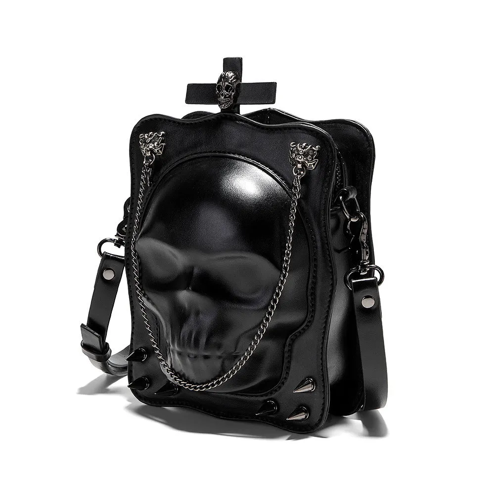 Black mini square crossbody bag with embossed skull design, metal chain strap, and zip opening.
