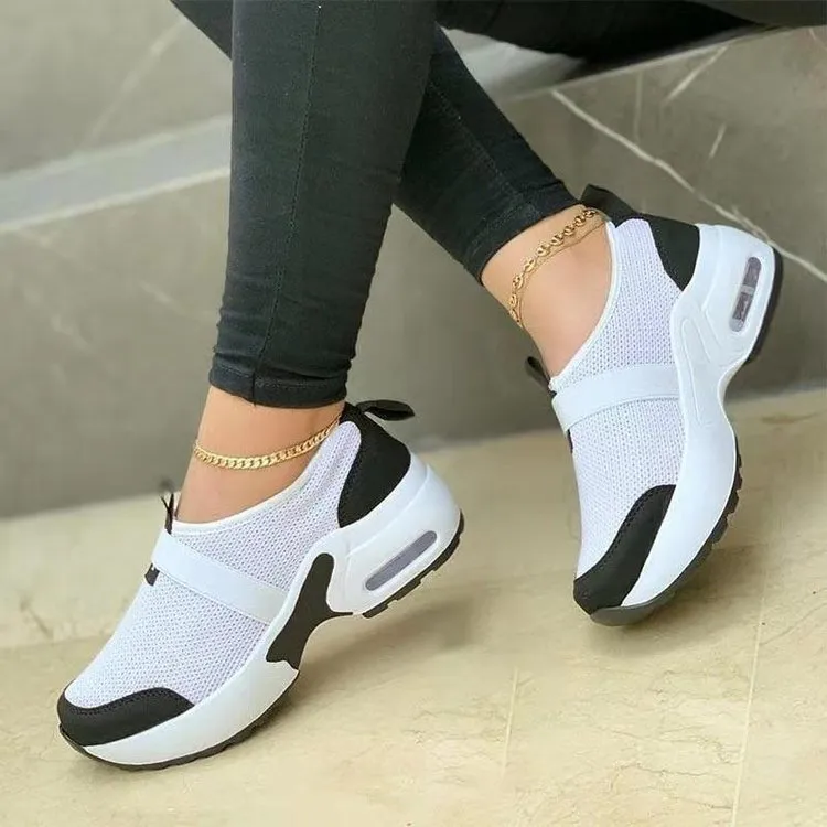 Women's flat sneakers in light grey with mesh upper, round toe, and rubber sole on a white background