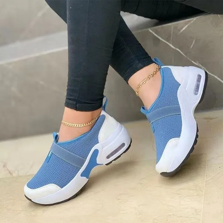 Women's flat sneakers in light grey with mesh upper, round toe, and rubber sole on a white background