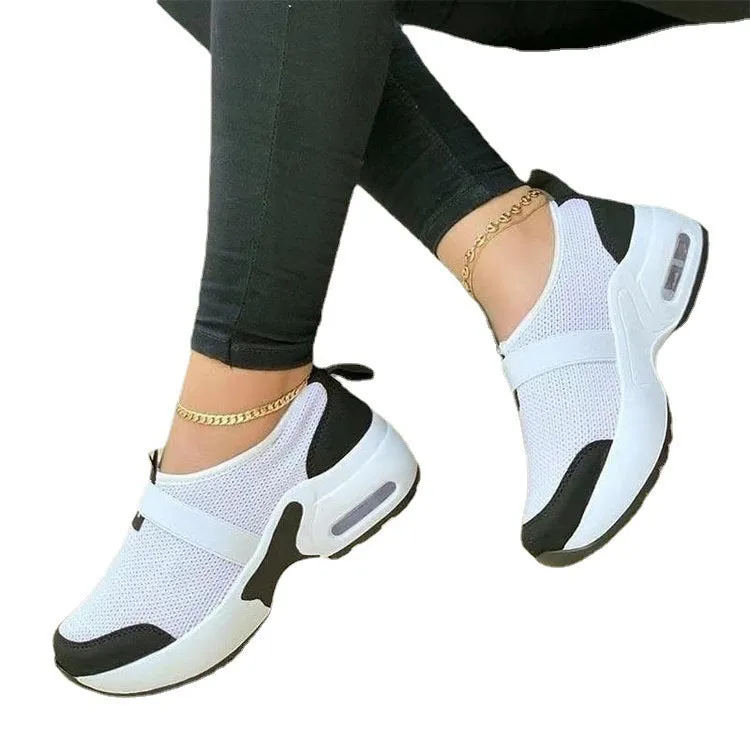 Women's flat sneakers in light grey with mesh upper, round toe, and rubber sole on a white background