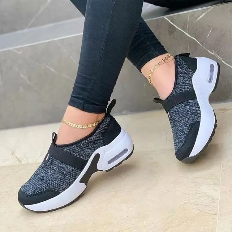 Women's flat sneakers in light grey with mesh upper, round toe, and rubber sole on a white background
