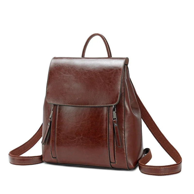 Large black square leather women's backpack with double straps and a cover opening.