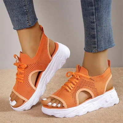Lace-up sandals for women with thick rubber sole and mesh upper in orange colour, flat design