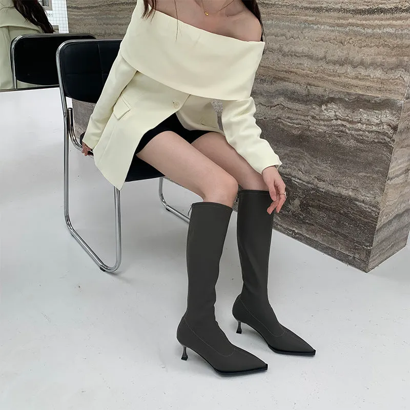 Women's black pointed toe below knee stiletto heel boots with a back zipper on display.
