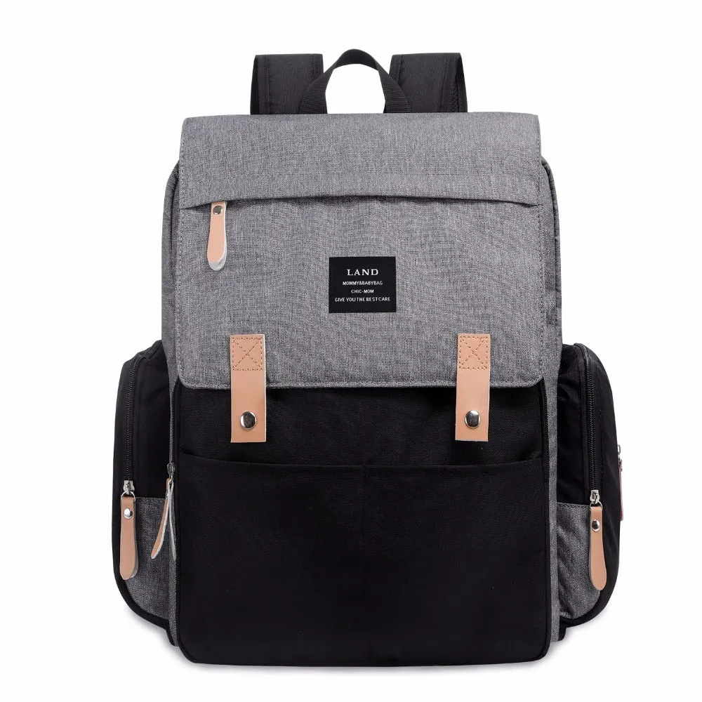 LAND Mommy large grey Oxford cloth diaper backpack with changing mat, shown on a table