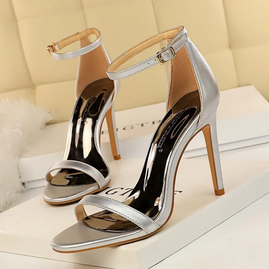 Women's open toe ankle-strap high heels with a buckle fastening, shown in one of six available colours.