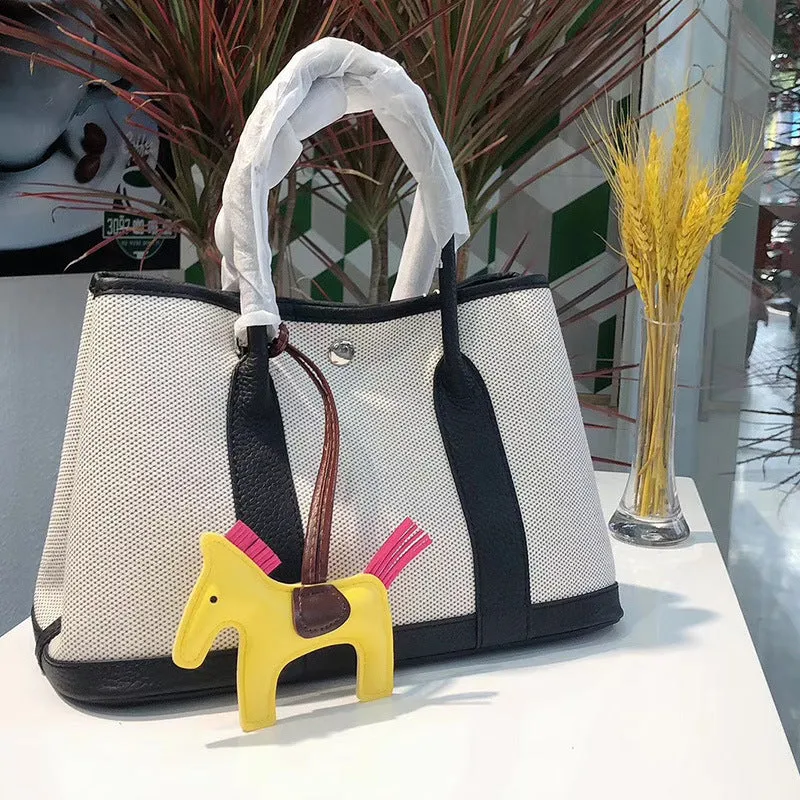 Women's canvas crossbody tote bag with leather trim in bucket shape showing internal organisation pockets.