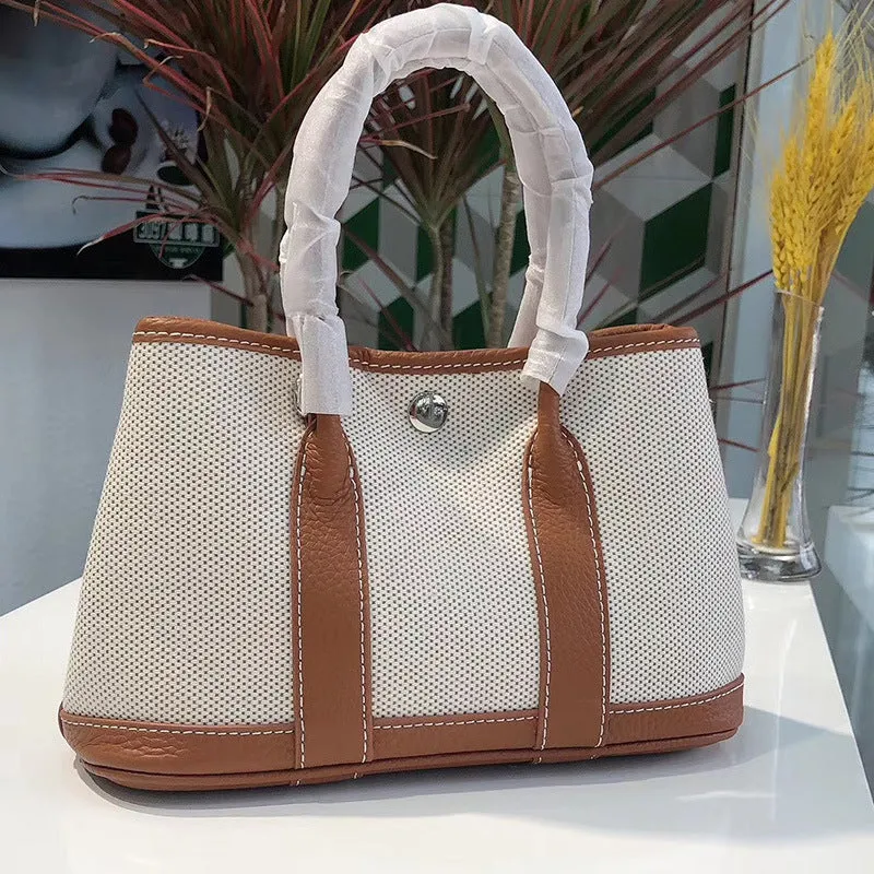 Women's canvas crossbody tote bag with leather trim in bucket shape showing internal organisation pockets.
