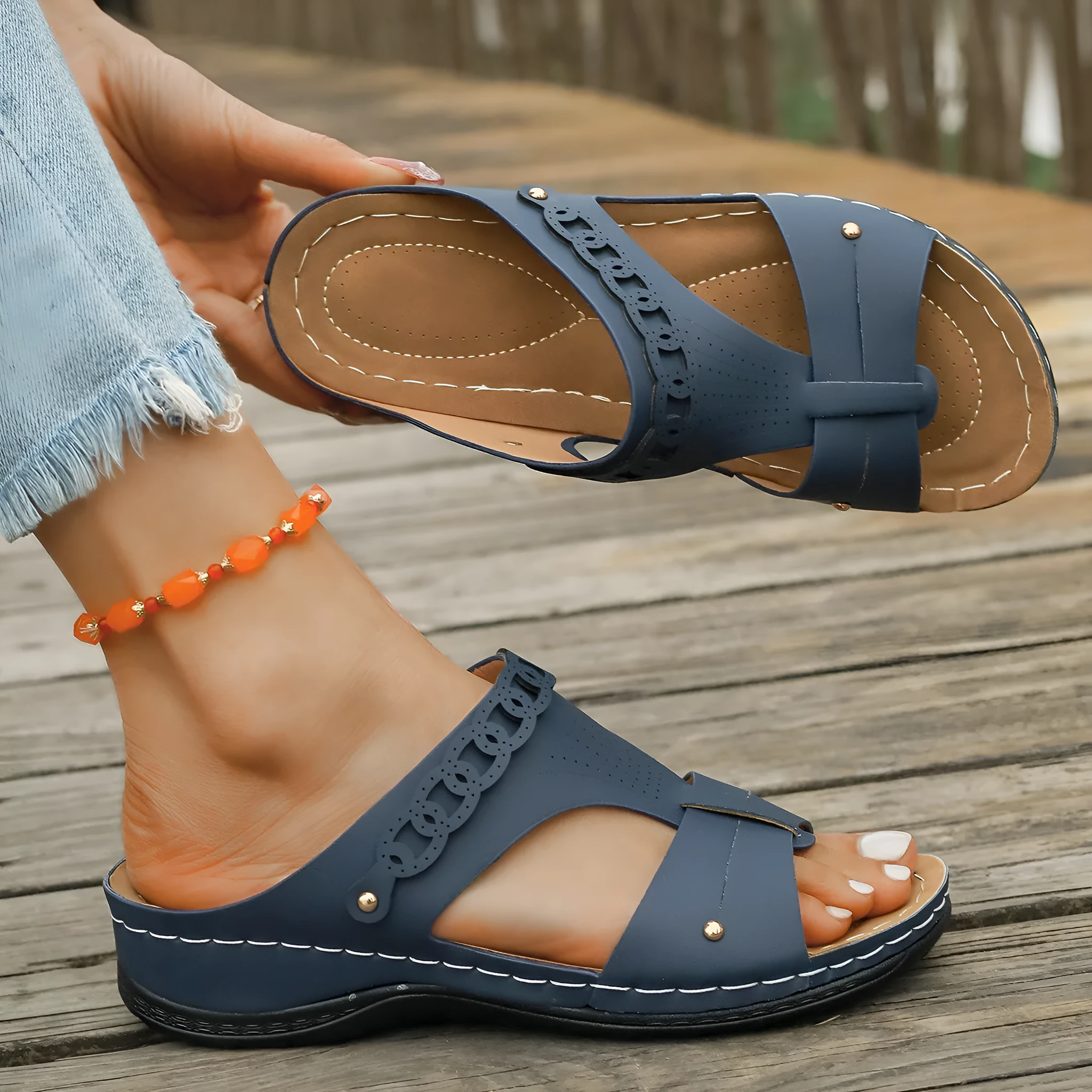Women's blue roman style slipper with slope heel and fish mouth toe on a white background