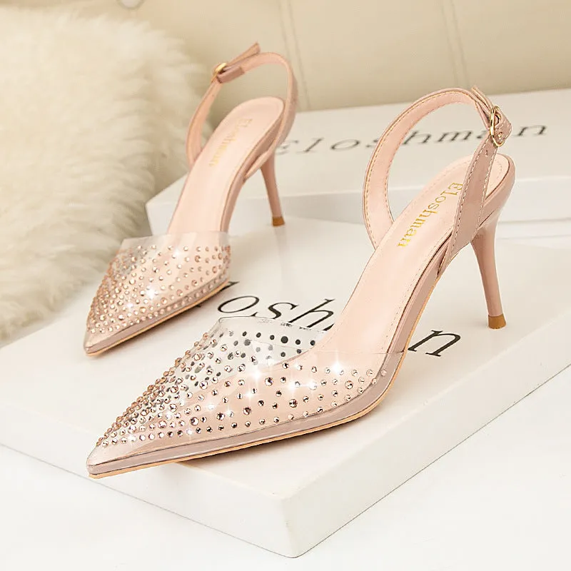 Women's black pointed low-cut stiletto high heels with buckle closure on a light background