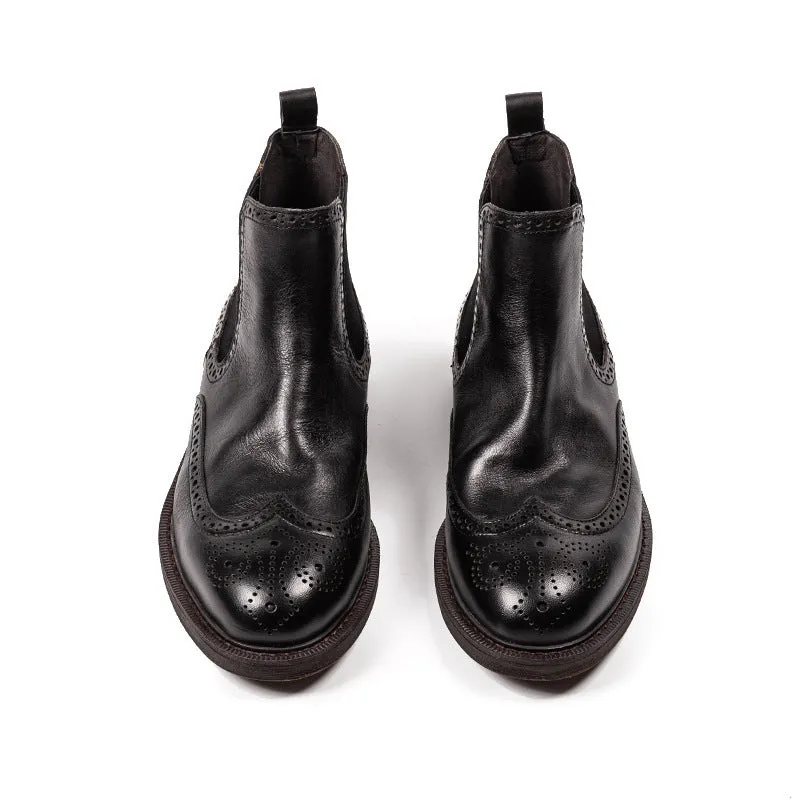 Men's black Chelsea boots with brogue carved genuine leather upper and rubber sole, side view