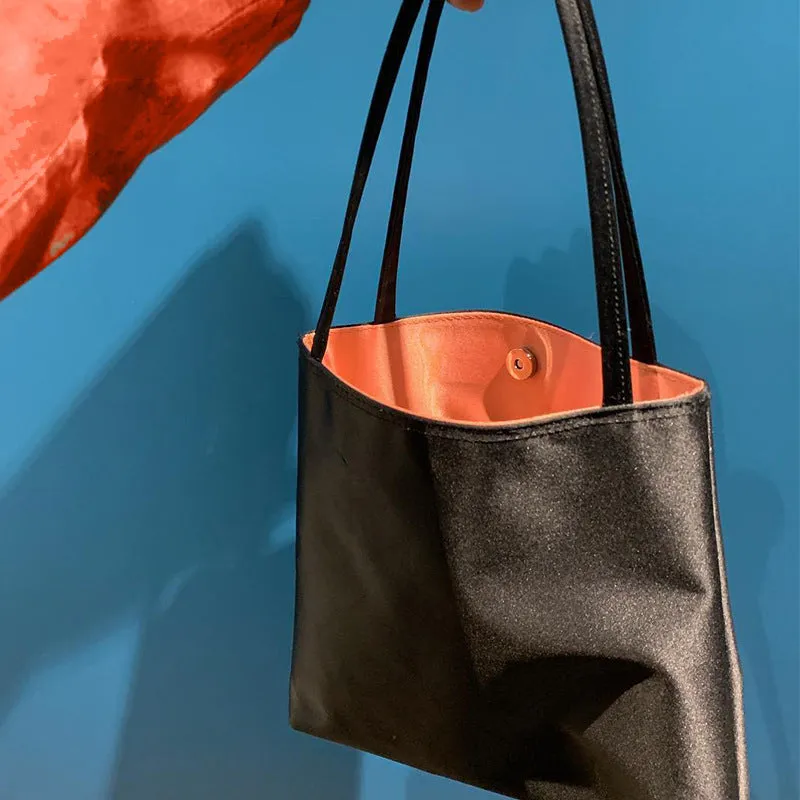 Glossy black women's bucket handbag with soft PU surface, fold design, and soft carry handle, 25cm height
