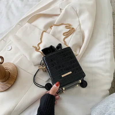Small black women's chain-strap messenger shoulder bag with a bucket shape and zip opening.