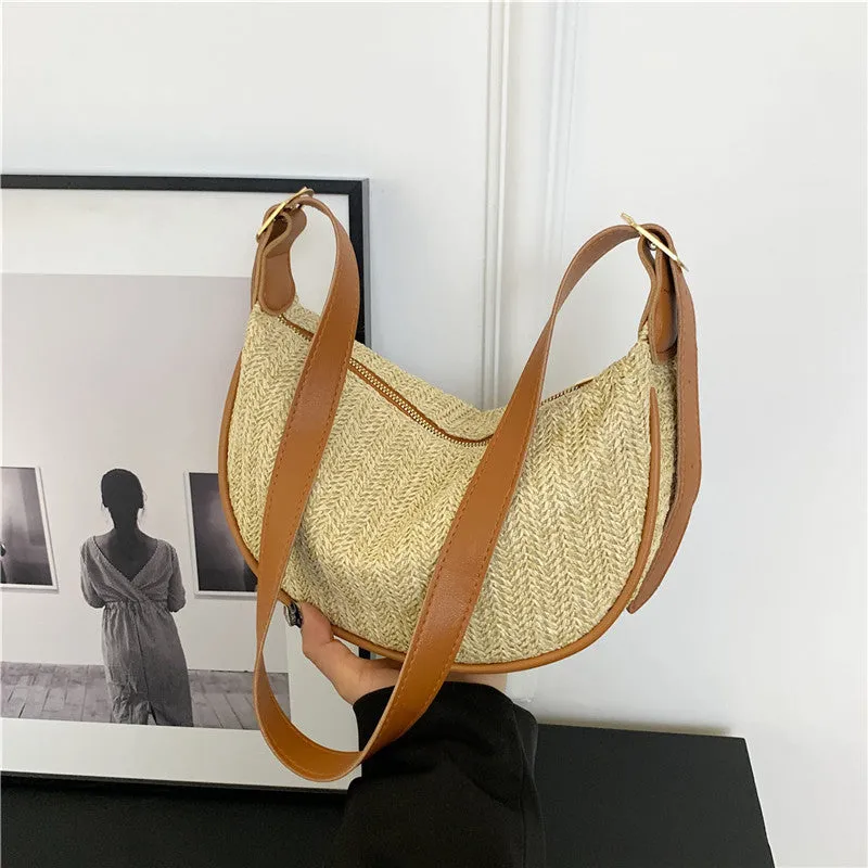 Women's straw woven crossbody bag showing woven texture and adjustable strap with internal phone and document pockets