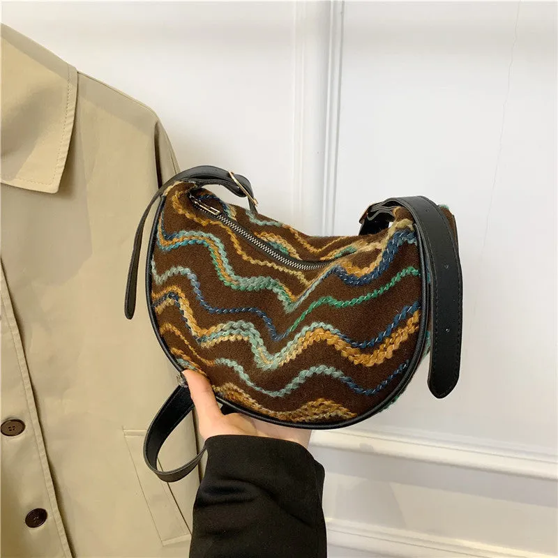 Women's straw woven crossbody bag showing woven texture and adjustable strap with internal phone and document pockets